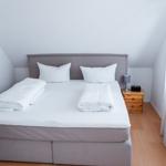 Schlafzimmer mit Doppelbett, Nachttisch und Fenster