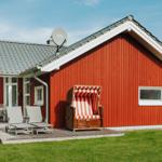 Rotes Holzhaus mit Terrasse, Strandkorb und Garten