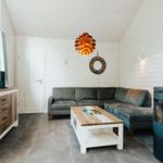 Wohnzimmer mit Sofa, Kamin und Fernseher an Wand