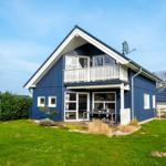 Blau gestrichenes Haus mit Balkon und Terrasse im Garten