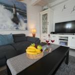 Wohnzimmer mit Sofa, Fernseher und Küchenzeile.