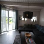 Wohnzimmer mit Sofa, Couchtisch und Blick auf Garten