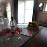 Auf dem Tisch stehen zwei Weingläser, eine Flasche Rosé und eine Obstschale.
