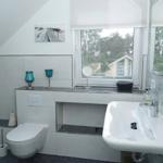 Badezimmer mit Waschbecken, Toilette und Fensterblick