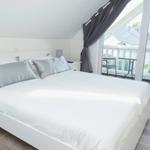 Schlafzimmer mit Doppelbett und Balkonansicht