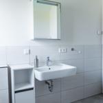 Badezimmer mit Waschbecken, Spiegelschrank und Unterschrank.