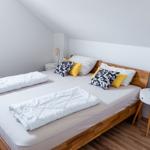 Schlafzimmer mit Doppelbett, Holzboden und zwei Nachttischen.