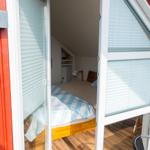 Schlafzimmer mit Bett und Schrank hinter Glastür