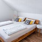 Schlafzimmer mit Doppelbett, zwei Nachttischen und Fenster.