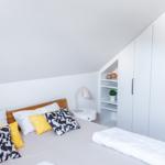 Schlafzimmer mit Bett, Kleiderschrank und Nachttisch.