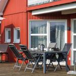 Roter Holzhaus mit Terrasse, Tisch, Stühle und Sonnenschirm