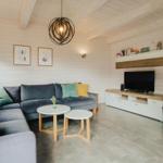 Wohnzimmer mit Sofa, TV und Kaminofen.
