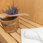 Holzwaschbecken mit Lavendel und Löffel auf Bank in Sauna