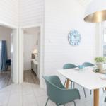 Essbereich mit Tisch, Stühlen und Wanduhr. Durchgänge zu Schlafzimmern.