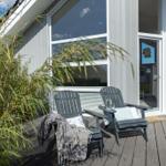 Terrasse mit zwei Stühlen, Glasfront und Bambuspflanze