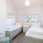 Zwei Betten, Schrank, Nachttisch und Fenster mit Blick.