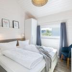 Schlafzimmer mit Doppelbett, Fenster und Schrank.