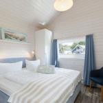 Schlafzimmer mit Bett, Stuhl und Fensterblick