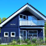 Blau gestrichenes Haus mit Balkon und Fenstern. Nummer 3. Umzäunt mit Holzzaun.