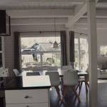 Küche mit Essbereich und Wohnzimmer mit Sofa und Fenstern.