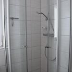 Dusche mit Glaswand und Handbrause in einem Badezimmer