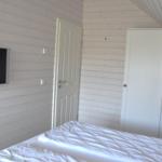Schlafzimmer mit Bett, Schrank und Wandfernseher.