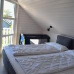 Schlafzimmer mit Doppelbett, Spielzeug und Balkonansicht.