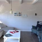 Wohnzimmer mit Sofa, Sesseln, Tisch und Wanddekoration.