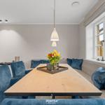 Esszimmer mit Holztisch, blauen Stühlen und Fensterblick.