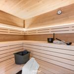 Sauna mit Holzbank, Thermometer und Badetüchern