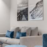 Wohnzimmer mit Sofa, Kissen und Wandbildern
