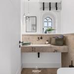 Bad mit Waschbecken, Spiegel und Badezimmerfenster.