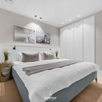 Schlafzimmer mit Bett, Kleiderschrank und Wandbildern.