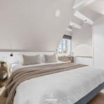 Schlafzimmer mit Dachschrägen, Bett, Schrank und Fenster.