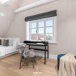 Schlafzimmer mit Dachschräge, Bett, Schreibtisch und Fenster.