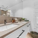 Badezimmer mit Doppelwaschbecken, Spiegelschrank und Heizkörper