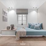 Schlafzimmer mit Bett, Fenster und Sauna im Hintergrund.