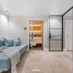 Wohnbereich mit Sauna, Sitzbank und blauem Sessel.