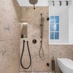 Dusche mit Duschbrause und Fenster im Bad