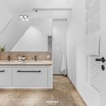 Badezimmer mit Doppelwaschbecken, Spiegelschrank und Heizkörper