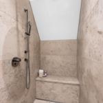 Duschkabine mit Steinwand und Sitzbank