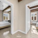Zwei Schlafzimmer mit Holzbalken, Fenstern und Betten