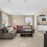 Wohnzimmer mit Ecksofa, Couchtisch und Blick in die Küche.