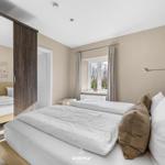 Schlafzimmer mit Doppelbett, Fenster und Spiegeltür