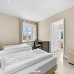 Zimmer mit zwei Betten, Schreibtisch und Blick aus dem Fenster.