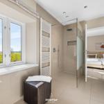 Badezimmer mit Dusche, Fensterblick auf Felder und Blick in Schlafzimmer