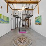 Halle mit Treppe, Kunst an den Wänden und Stern an der Decke.