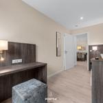 Schlafzimmer mit Schreibtisch und Fernseher. Durchgang zur Küche.