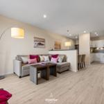 Wohn- und Essbereich mit Sofa, Tisch und Küchenbereich.