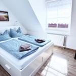 Schlafzimmer mit Doppelbett, Fenster und Kleiderschrank.